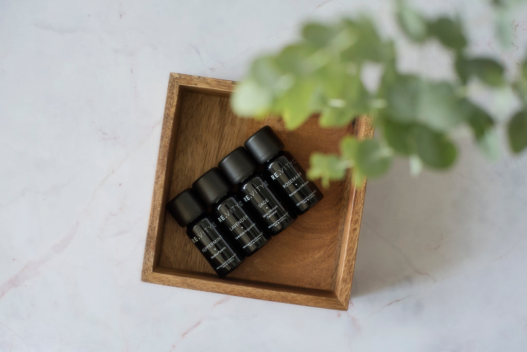 4 organic essential oils are set inside a box with greenery